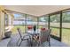 Screened-in patio features a dining table with seating and overlooks the fenced-in backyard with lush landscaping at 1720 Fruitridge St, Brandon, FL 33510