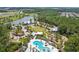 Stunning aerial view of the community pool and amenity center with manicured landscaping and a serene lake at 17589 Cruiser Bnd, Land O Lakes, FL 34638