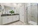 Modern bathroom featuring a double vanity with granite counters and a glass-enclosed shower at 17589 Cruiser Bnd, Land O Lakes, FL 34638