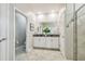 Well-lit bathroom with a double vanity, tiled flooring, modern fixtures, and a glass-enclosed shower at 17589 Cruiser Bnd, Land O Lakes, FL 34638