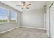 Bedroom features neutral carpet, ceiling fan, double windows, and closet at 17589 Cruiser Bnd, Land O Lakes, FL 34638