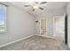 Comfortable carpeted bedroom with a ceiling fan, a window, and a glimpse into the bathroom at 17589 Cruiser Bnd, Land O Lakes, FL 34638