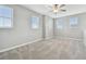 Bright bedroom featuring multiple windows, neutral color palette, ceiling fan, and plush carpeting at 17589 Cruiser Bnd, Land O Lakes, FL 34638