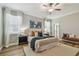 Inviting bedroom with a ceiling fan, wood floors, and neutral tones, complemented by bright natural light at 17589 Cruiser Bnd, Land O Lakes, FL 34638