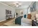 Comfortable bedroom with wood floors, a large rug, stylish decor, and a glimpse into the bathroom at 17589 Cruiser Bnd, Land O Lakes, FL 34638