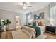 Bright bedroom featuring a ceiling fan, neutral walls, and coordinated decor; view of the adjoining bathroom at 17589 Cruiser Bnd, Land O Lakes, FL 34638