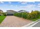 Charming home featuring a paved driveway, lush landscaping, and a screened pool enclosure, creating curb appeal at 17589 Cruiser Bnd, Land O Lakes, FL 34638