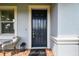 Close up of front door with a welcome mat and wicker chair at 17589 Cruiser Bnd, Land O Lakes, FL 34638