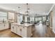 Open-concept kitchen and living area features a large island, pendant lighting, and sliding doors to the pool at 17589 Cruiser Bnd, Land O Lakes, FL 34638