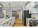 Modern kitchen featuring white cabinets, stainless steel appliances, a pantry, and a marble island countertop at 17589 Cruiser Bnd, Land O Lakes, FL 34638