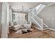 Cozy living room features hardwood floors, neutral palette, and a white staircase at 17589 Cruiser Bnd, Land O Lakes, FL 34638