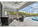 Screened patio with a ceiling fan and comfortable seating, ideal for outdoor relaxation at 17589 Cruiser Bnd, Land O Lakes, FL 34638