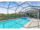 Sparkling screened pool with a spa, water feature, pavers, and outdoor seating, perfect for relaxation and entertainment at 17589 Cruiser Bnd, Land O Lakes, FL 34638