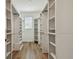 Spacious walk-in closet with custom shelving and wood flooring at 17589 Cruiser Bnd, Land O Lakes, FL 34638