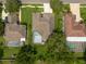Aerial view of homes with screened-in pools, well-manicured lawns and mature landscaping in a quiet neighborhood at 18518 Bittern Ave, Lutz, FL 33558