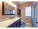 Well-lit bathroom featuring a large mirror, wooden vanity, and a bathtub with a patterned shower curtain at 18518 Bittern Ave, Lutz, FL 33558