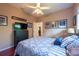 Comfortable bedroom featuring a ceiling fan, dark wood floors, and a black dresser with a TV at 18518 Bittern Ave, Lutz, FL 33558