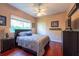 Cozy bedroom boasts a window, closet, ceiling fan, TV and hardwood floors at 18518 Bittern Ave, Lutz, FL 33558