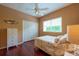 Comfortable bedroom offers a bright window, ceiling fan, closet and hardwood floors at 18518 Bittern Ave, Lutz, FL 33558