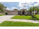 Inviting single-story residence with a three-car garage and pristine landscaping at 18518 Bittern Ave, Lutz, FL 33558