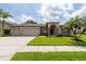 Charming single-story home with a three-car garage and well-manicured lawn at 18518 Bittern Ave, Lutz, FL 33558