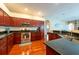 The open kitchen features stainless appliances, granite counters, and cherry wood cabinets at 18518 Bittern Ave, Lutz, FL 33558