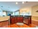 Open kitchen features wood floors, stainless dishwasher, and black granite countertops at 18518 Bittern Ave, Lutz, FL 33558