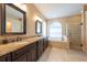 Bright main bathroom features a double vanity, a soaking tub, and a glass-enclosed shower at 18518 Bittern Ave, Lutz, FL 33558