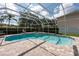 Inviting screened-in pool and jacuzzi area, with brick patio and lush greenery at 18518 Bittern Ave, Lutz, FL 33558