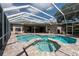 Sparkling screened-in pool with attached spa and brick paver deck offers a luxurious outdoor living experience at 18518 Bittern Ave, Lutz, FL 33558