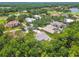 Aerial view of the neighborhood showcasing lush greenery, a golf course, and several beautiful homes around a pond at 1877 Muirfield Way, Oldsmar, FL 34677