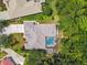 Aerial view of an estate home featuring screened-in pool, pristine landscaping, and mature trees in the backyard at 1877 Muirfield Way, Oldsmar, FL 34677