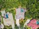 Aerial shot of a single-Gathering home showcasing a private pool and spa surrounded by lush landscaping and mature trees at 1877 Muirfield Way, Oldsmar, FL 34677
