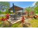 Backyard patio with wrought iron furniture and a pergola. Surrounded by mature tropical foliage at 1877 Muirfield Way, Oldsmar, FL 34677