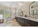 Bright bathroom featuring double vanity, soaking tub, and dark wood cabinets at 1877 Muirfield Way, Oldsmar, FL 34677
