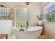Bright bathroom with soaking tub, tile surround and a unique glass block window at 1877 Muirfield Way, Oldsmar, FL 34677