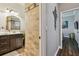 Bathroom featuring a stone wall, vanity with gold faucet, and door to another room at 1877 Muirfield Way, Oldsmar, FL 34677