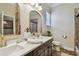 Bathroom with double vanity sinks, marble countertops, decorative mirrors, and tile flooring at 1877 Muirfield Way, Oldsmar, FL 34677