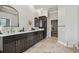 Stylish bathroom with a double vanity, marble countertop, dark wood cabinets and tile flooring at 1877 Muirfield Way, Oldsmar, FL 34677