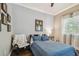 Bright bedroom with wood floors, a side table lamp, and comfortable furnishings at 1877 Muirfield Way, Oldsmar, FL 34677