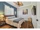 Comfortable bedroom with a ceiling fan, a decorative painting, and hardwood flooring at 1877 Muirfield Way, Oldsmar, FL 34677