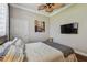 Aesthetic bedroom with ceiling fan, wall-mounted television and decorative painting at 1877 Muirfield Way, Oldsmar, FL 34677