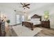 Primary bedroom features a ceiling fan, wood floors, and doors leading outside to a deck or patio at 1877 Muirfield Way, Oldsmar, FL 34677