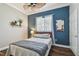 Cozy bedroom with stylish blue accent wall, window, and ceiling fan for added comfort at 1877 Muirfield Way, Oldsmar, FL 34677