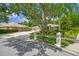 Well-maintained home with a landscaped front yard, mature trees, and a circular driveway at 1877 Muirfield Way, Oldsmar, FL 34677