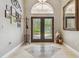 Inviting foyer with decorative tile flooring, an arched transom window, and double front doors at 1877 Muirfield Way, Oldsmar, FL 34677