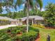 Beautiful home exterior showcasing a three-car garage and lush landscaping at 1877 Muirfield Way, Oldsmar, FL 34677
