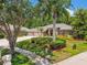 Home exterior features a three-car garage, lush landscaping, and palm trees at 1877 Muirfield Way, Oldsmar, FL 34677