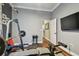 Spacious home gym featuring a weight rack and flat-screen TV, perfect for fitness enthusiasts at 1877 Muirfield Way, Oldsmar, FL 34677