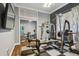 Well equipped home gym featuring weightlifting equipment, mirrored closet, and tv for entertainment at 1877 Muirfield Way, Oldsmar, FL 34677